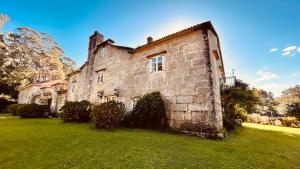 an old brick building on a grass field at Los Lagares Manor House in Deán Pequeño
