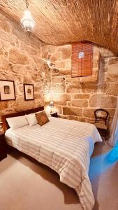 a bedroom with a large bed in a stone wall at Los Lagares Manor House in Deán Pequeño