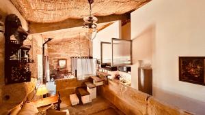 a living room with a stone wall and a chandelier at Los Lagares Manor House in Deán Pequeño