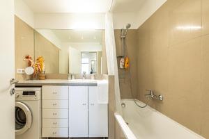 a bathroom with a sink and a washing machine at Genuine Vienna Home by JR City Apartments in Vienna +42 photos