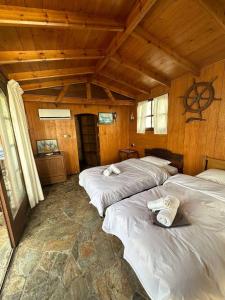 three beds in a room with wooden walls at 4BR by the Sea, Family friendly, Breathtaking View in Avia