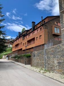 een groot bakstenen gebouw aan de kant van een straat bij La Molina Alp c Puigmal in Girona