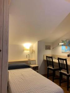 een slaapkamer met een bed, een bureau en 2 stoelen bij La Molina Alp c Puigmal in Girona +16 foto's