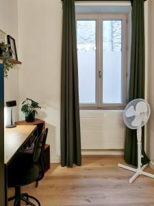 a room with a desk and a window with green curtains at La Virgule - Dole centre - Wifi - Calme in Dole
