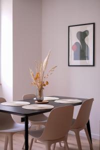 a dining room with a black table and chairs at La Virgule - Dole centre - Wifi - Calme in Dole