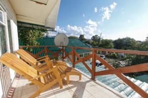 2 sedie in legno sedute su un portico con vista sulla piscina di Jamilya's B&B Guest House a Karakol