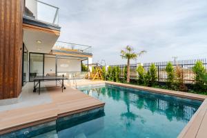a house with a swimming pool with a table on a deck at 5-Bedroom Villa with Pool & Sauna in Dosemealti