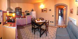 a kitchen with a table and a kitchen with a refrigerator at Apartment with one bedroom, kitchen, bathroom Garden and shared pool in Chianni