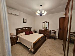 切法卢Cefalù Bella的一间卧室配有一张床、镜子和吊灯