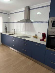a kitchen with blue cabinets and a sink at Las Olas Chipiona in Chipiona