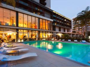 a swimming pool in front of a building at Novotel Monte-Carlo in Monte Carlo
