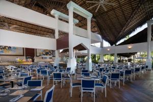 a restaurant with tables and chairs in a building at Impressive Punta Cana - All Inclusive in Punta Cana