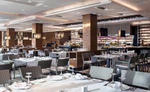 a dining room with white tables and chairs at Hotel AR Golf Almerimar in Almerimar
