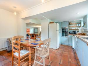 a kitchen and dining room with a wooden table and chairs at Church House Cottage in East Stour