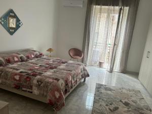 sypialnia z łóżkiem, krzesłem i oknem w obiekcie Casa vacanza da Paola w Trapani