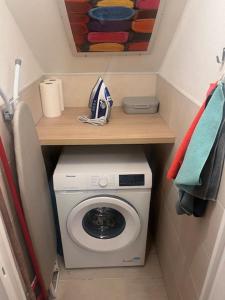 a small bathroom with a washing machine and a shelf at Maison cosy proche Paris-Orly in Vigneux-sur-Seine