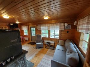 Una sala de estar con un sofá y un televisor. en Arola 3 rantamökki, en Syöte