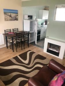 a living room with a table and chairs and a kitchen at California Sands Chalet in Scratby