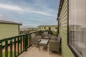 a balcony with chairs and tables on a building at St Andrews Holiday Park - Kinkell Braes No 16 in St. Andrews