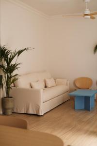 ein Wohnzimmer mit einem weißen Sofa und einem blauen Tisch in der Unterkunft CASA SIRFANTAS Málaga in Málaga + 31 Fotos
