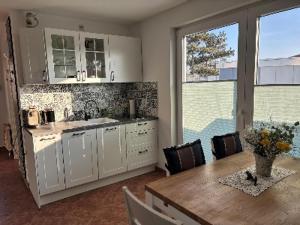 a kitchen with a wooden table and a dining room at Strandhaus in der Düne in Dierhagen