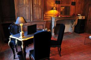 Les Glycines Vézelay في فيزيلاي: غرفة بها طاولة مع جهاز كمبيوتر محمول