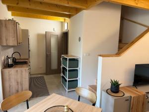 a living room with a table and a kitchen at Náš sen - Domek in Svratouch