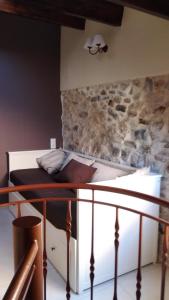 a bed in a room with a stone wall at Casa Tòful in Alfara de Carles