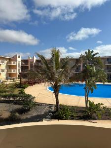 a view of a resort with palm trees and a swimming pool at Tropical Paradise in Santa Maria