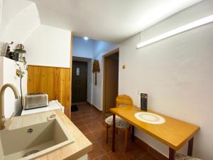 - une cuisine avec un évier et une table en bois dans l'établissement Piața Sfatului Brassai Apartments, à Braşov 28 autres photos