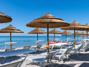 a group of chairs and umbrellas on a beach at Palazzo Tirso MGallery Cagliari in Cagliari