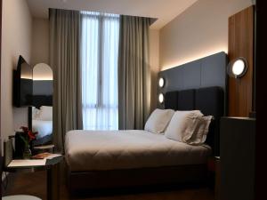 Кровать или кровати в номере Palazzo Tirso MGallery Cagliari