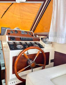 un tableau de bord d'un bateau avec un volant de direction en bois dans l'établissement Barco muy acogedor en Valencia, à Puebla de Farnals