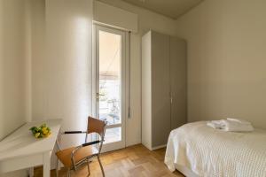 パドヴァにあるLiberty Lux House - Padovaのベッドと机と窓のある寝室