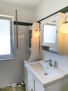 un baño con lavabo y espejo en 28 Fehmarn An der Reiterkoppel 49b EG, en Burg auf Fehmarn 8 fotos más
