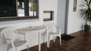 a white table and two white chairs in a room at Siesta Villa Motel in Gladstone