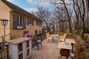 une arrière-cour avec des tables et des chaises ainsi qu'une maison dans l'établissement Maison Sur le Causse Corrézien, à Saint-Cernin-de-Larche