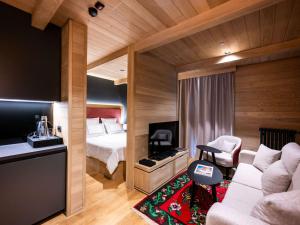 ein Hotelzimmer mit einem Bett und einer Couch in der Unterkunft Swissôtel Resort Kolasin in Kolašin