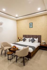 a bedroom with a bed and a table and chairs at Atrium Hotel By Bestinn Leisure in Bengaluru +35 photos