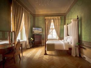 sypialnia z łóżkiem, biurkiem i oknami w obiekcie The Mozart Prague w Pradze