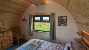 a bedroom with a bed and a window at Evas Howe Lodge in Orkney