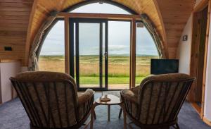 two chairs and a table in front of a window at Evas Howe Lodge in Orkney