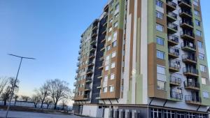 a tall apartment building in front of a street at Silver Apartman in Siófok