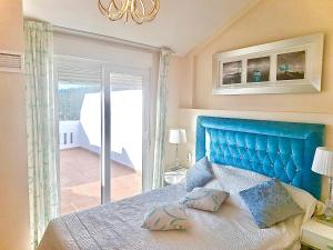 a bed with a blue headboard in a bedroom at Classypropety3 in Manilva +13 photos
