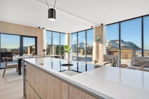 a kitchen with a counter with a view of mountains at Arctic Serenity Lodge Lofoten - jacuzzi & sauna LL12 in Lyngværet +30 photos