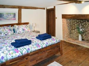 a bedroom with a bed with two blue pillows on it at Rose Cottage in Bethersden +9 photos
