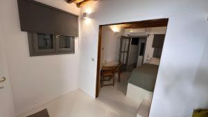 a small room with a bedroom and a bed and a mirror at Amerissas studios 2 in Skiros