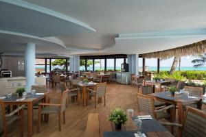 a restaurant with tables and chairs and the ocean at Impressive Punta Cana - All Inclusive in Punta Cana