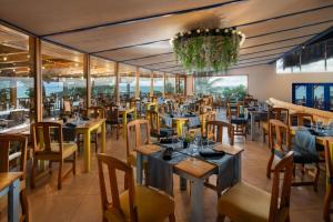 a restaurant with tables and chairs and a chandelier at Impressive Punta Cana - All Inclusive in Punta Cana