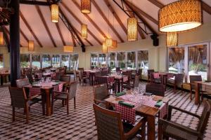 a dining room with tables and chairs and chandeliers at Impressive Punta Cana - All Inclusive in Punta Cana